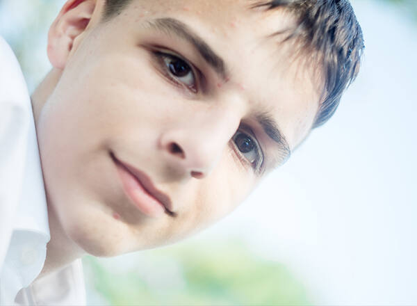 A teenage boy looking thoughtfully off to the side